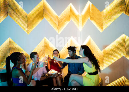 Group of friends toasting un verre de champagne tout en célébrant l'anniversaire Banque D'Images