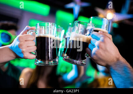 Groupe d'amis toasting beer mugs Banque D'Images