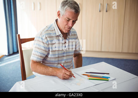 Man en utilisant un livre de coloriage Banque D'Images