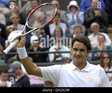 Roger Federer, de Suisse, fait son raquette à la foule après sa victoire contre Juan Martin Del Potro en Argentine lors du Championnat d'Angleterre de tennis sur gazon à Wimbledon. Banque D'Images