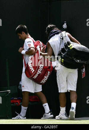 Le Novak Djokovic de Serbie (à gauche) part du court, suivi par le Rafael Nadal d'Espagne après avoir concédé le match lors du Championnat d'Angleterre de tennis sur gazon à Wimbledon. Banque D'Images