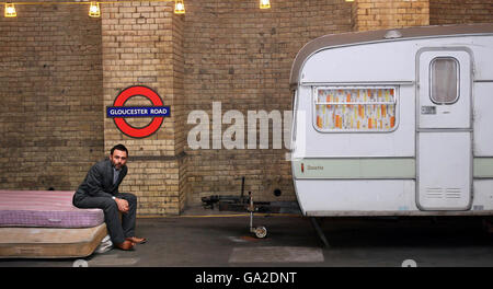 Brian Griffiths se tient avec son Art installation sur une plate-forme à la station de métro Gloucester Road, Londres. Banque D'Images