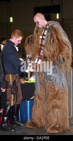 Un fan de Star Wars est aidé dans son costume « envoûtant » à la Convention Star Wars dans le centre Excel de Londres. Banque D'Images