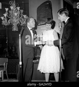 Le prix du meilleur spectacle dramatique britannique en 1961, remis à Shelagh Delaney et Tony Richardson pour le film « A Taste of Honey »,Est accepté en leur nom par Rita Tushingham et Murray Melvin de Richard Attenborough (à gauche) lors du premier dîner annuel de la Guilde des écrivains de télévision et d'écran à l'hôtel Dorchester.Londres.Mlle Tushingham et M. Melvin ont donné des performances très louées dans le film.M. Attenborough a été l'une des stars qui ont remis les prix de la Guilde aux scénaristes pour les films et la télévision en 1961. Banque D'Images