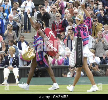 Aux États-Unis, venus Williams célèbre sa victoire alors que la russe Maria Sharapova (à droite) la suit hors du terrain lors du championnat de tennis de pelouse de toute l'Angleterre à Wimbledon. Banque D'Images