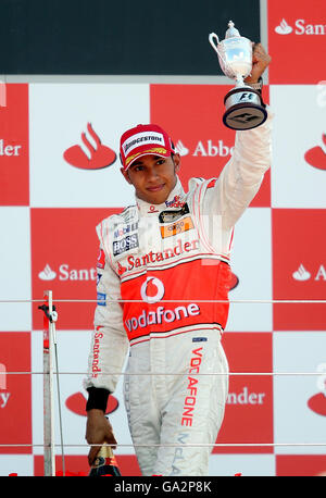 Lewis Hamilton, en Grande-Bretagne, se honde sur le podium après avoir pris la troisième place du Grand Prix britannique à Silverstone, dans le Northamptonshire. Banque D'Images