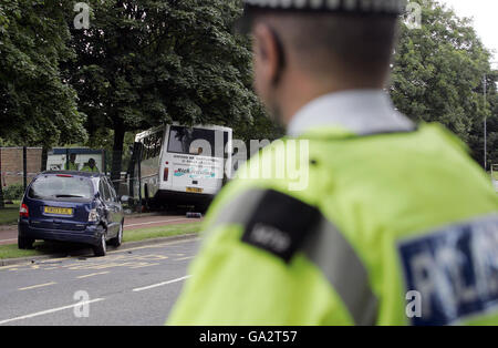 Les policiers regardent la scène après qu'un autobus scolaire transportant plus de 30 enfants ait été impliqué dans un accident à l'extérieur d'une école à Hartlepool. Banque D'Images