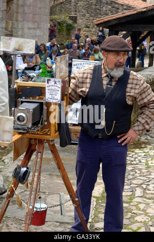 Un photographe de rue à Santillana del Mar a beaucoup d'affaires de touristes se rendant sur l'ancien village qui est situé à Banque D'Images