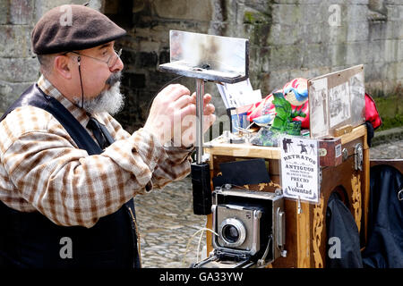 Un photographe de rue à Santillana del Mar a beaucoup d'affaires de touristes se rendant sur l'ancien village qui est situé à Banque D'Images