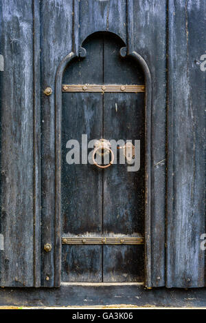 Très vieille porte en bois noir avec poignée et serrure de fer rouillé. Banque D'Images