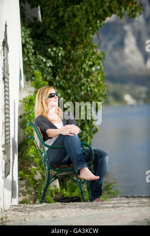 Jeune femme assise au soleil, détendue, Traunkirchen Haute-autriche, Autriche, Europe Banque D'Images