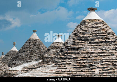 Groupe de trulli traditionnels des Pouilles, en pierre avec toits coniques et des pinacles, Alberobello, Bari province, région des Pouilles Banque D'Images
