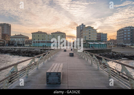 Jetée de vide avec des bancs sur la mer à Pesaro au coucher du soleil Banque D'Images