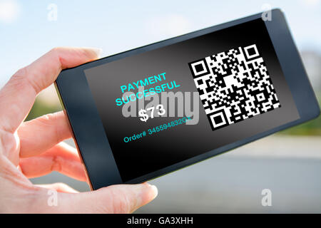 Femme dans le parc, main tenant le téléphone, de QR code transaction Banque D'Images