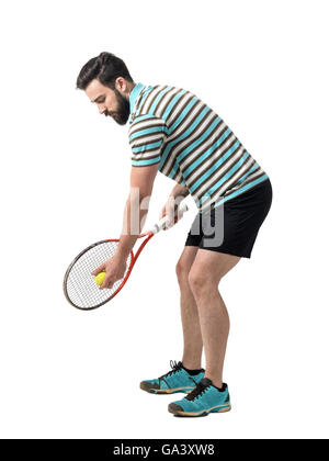 Jeune joueur de tennis polo shirt ball se préparer à servir. La pleine longueur du corps portrait studio isolated over white background. Banque D'Images