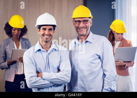 Portrait de deux architectes standing with arms crossed in office Banque D'Images