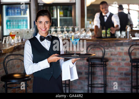 Portrait de bartender holding plateau avec verre de cocktail Banque D'Images