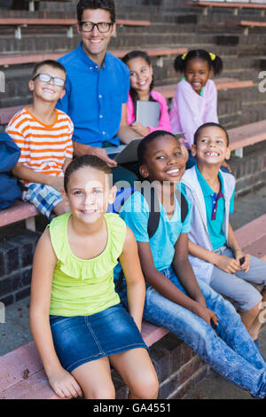 Portrait de l'enseignant et les enfants assis sur un banc Banque D'Images