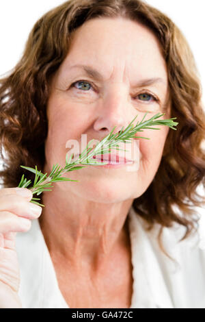 Portrait of mature woman smelling rosemary Banque D'Images