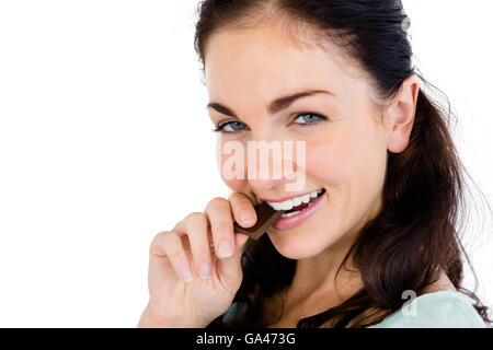 Close-up portrait of smiling woman eating chocolate bar Banque D'Images