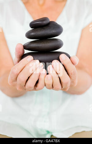 Midsection of woman holding pebbles Banque D'Images