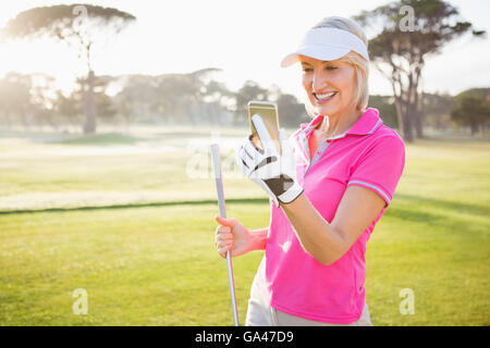 Golfeur femme à son téléphone portable Banque D'Images