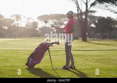 Vue latérale du woman carrying golf club Banque D'Images