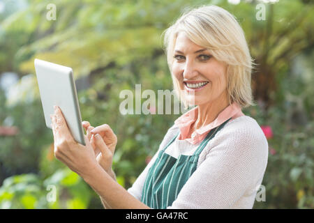 Mature female gardener using digital tablet Banque D'Images