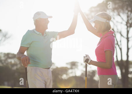 Golfeur heureux couple giving high five Banque D'Images