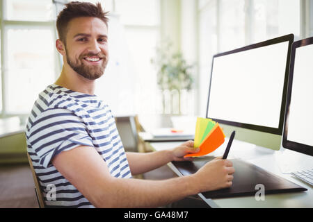 Portrait of businessman holding notes adhésives dans creative office Banque D'Images