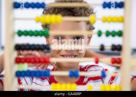 Cute boy playing with address in classroom Banque D'Images