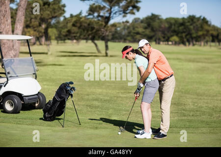 Vue de côté de l'enseignement de l'homme femme à jouer au golf Banque D'Images