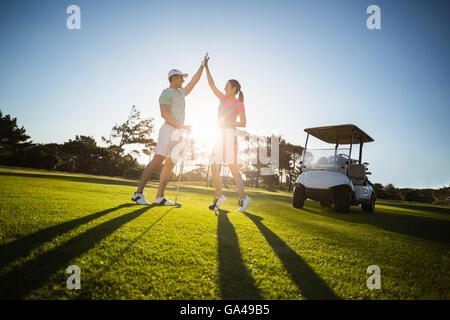 Joueur de golf heureux couple giving high five Banque D'Images