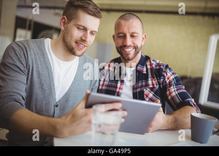 Vue de face d'hommes d'affaires à l'aide de digital tablets in office Banque D'Images