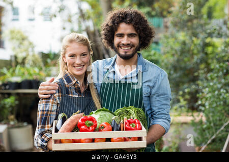 Heureux couple holding vegetables crate Banque D'Images