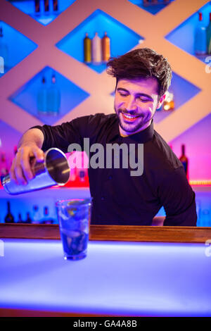 Bartender pouring cocktail dans le verre Banque D'Images