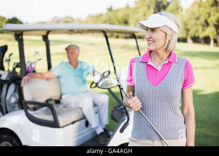 Happy mature woman holding golf club Banque D'Images