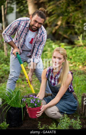 Portrait de jardiniers heureux avec plante en pot et une pelle à jardin Banque D'Images