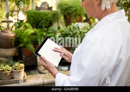 Female scientist using tablet computer à émissions de Banque D'Images