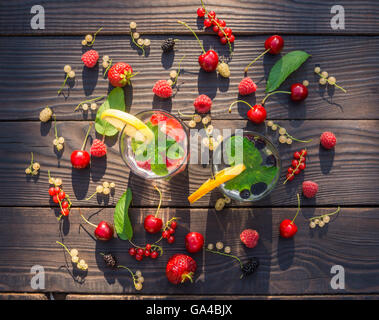 Deux tasses en verre avec verre de menthe et de fruits rouges sur le fond sombre des chambres Banque D'Images