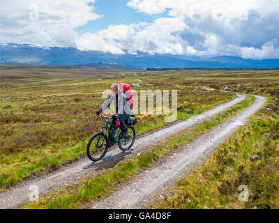 L'homme a pris sa retraite sur un vélo-emballage promenade dans les Highlands écossais Banque D'Images