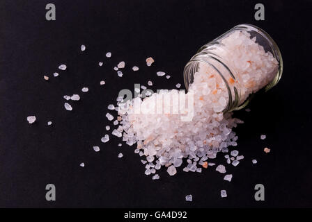 Gros grain de sel dans un verre Voyage Maldives sur fond noir Banque D'Images