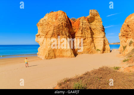 Tourist debout sur belle plage de Praia da Rocha, Algarve, Portugal Banque D'Images