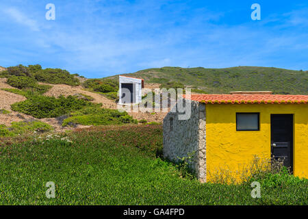 Petites maisons sur la colline verte construit pour surfeurs de Castelejo Beach sur la côte du Portugal Banque D'Images