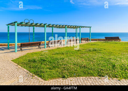 Des bancs et des pelouses vertes sur la promenade côtière de Luz ville, région de l'Algarve, Portugal Banque D'Images