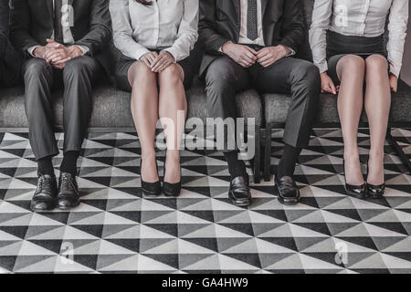 Les personnes en attente d'entrevue d'emploi assis dans une rangée Banque D'Images