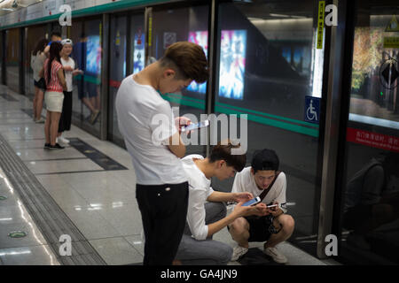 Les jeunes Chinois jouent avec leurs smartphones et les médias sociaux, à Beijing, Chine Banque D'Images