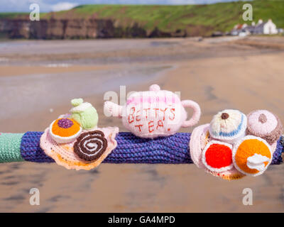 Bombardement de fils de lieu public de décoration avec des objets tricotés ici Bettys Théière et des gâteaux sur la main courante Saltburn Pier Banque D'Images