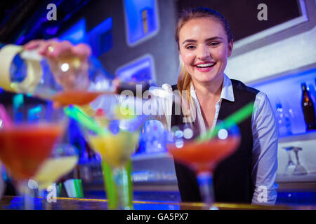 Smiling bartender pouring boire dans du verre Banque D'Images
