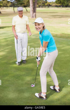 Portrait of woman holding golf club par l'homme Banque D'Images